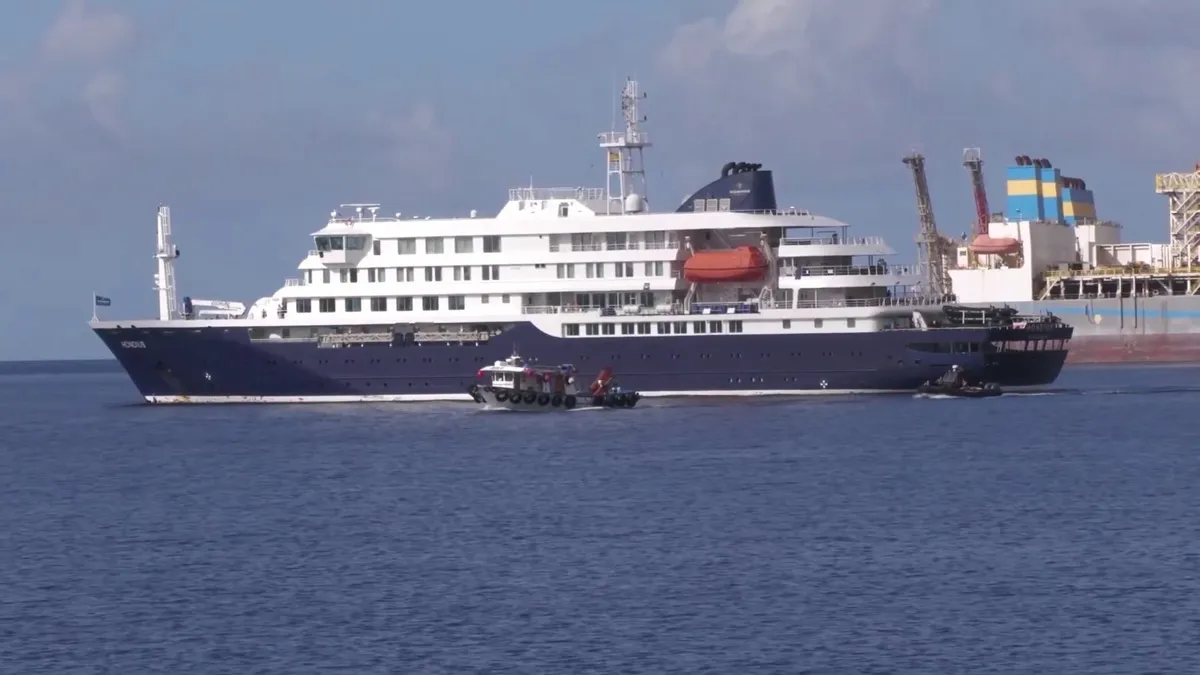 El barco de expedición Hondius, de casco azul oscuro y superestructura blanca, navegando cerca de la costa en mayo de 2026