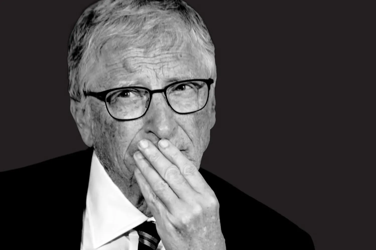 Bill Gates en retrato blanco y negro, con la mano sobre la boca, reflexionando.