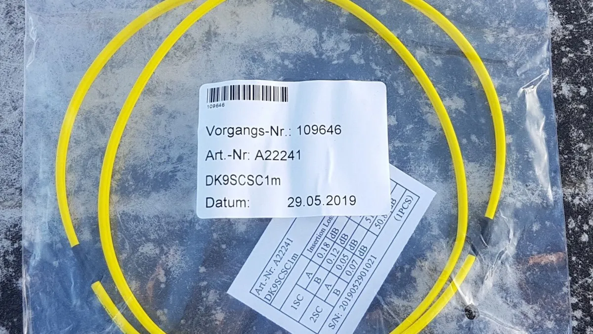 Fibras ópticas finas y conectores de un cable de conexión, con los extremos de cada hilo visibles