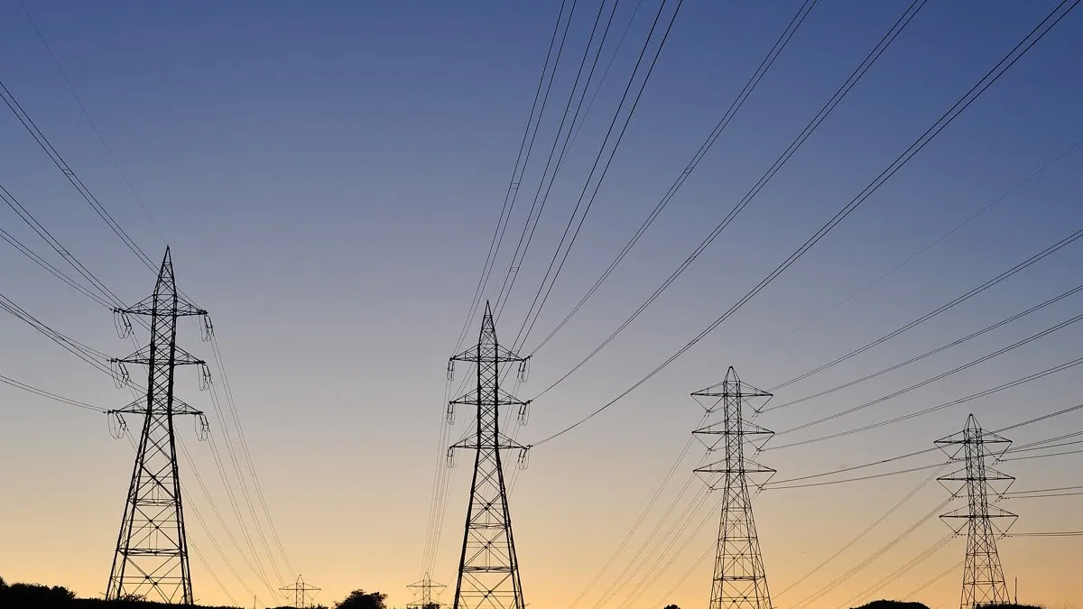 Torres y cables de una línea de transmisión eléctrica contra el cielo