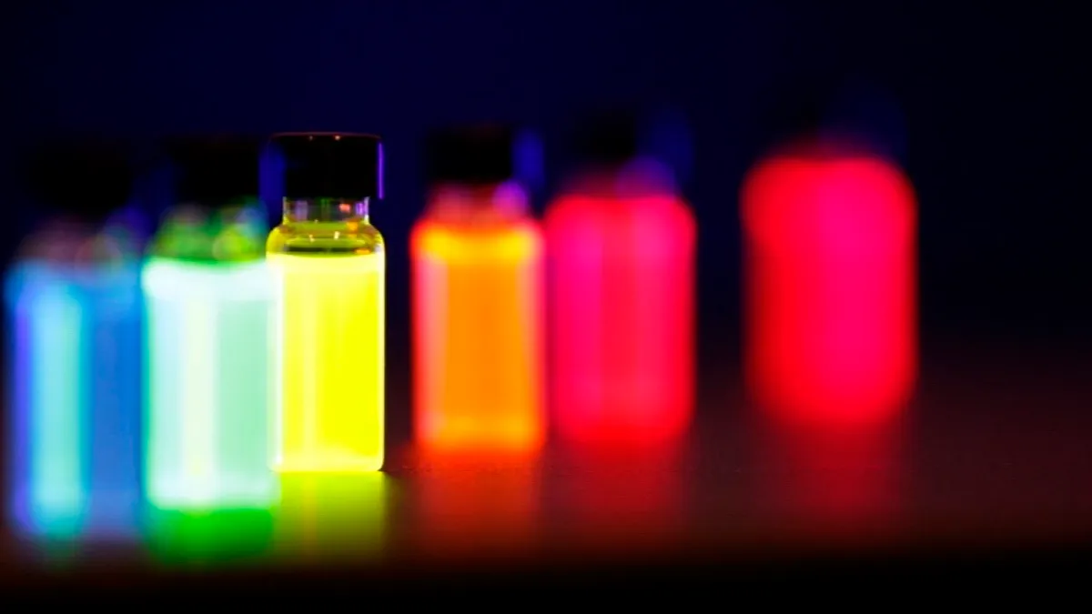 Viales con nanocristales semiconductores que brillan en distintos colores bajo luz ultravioleta