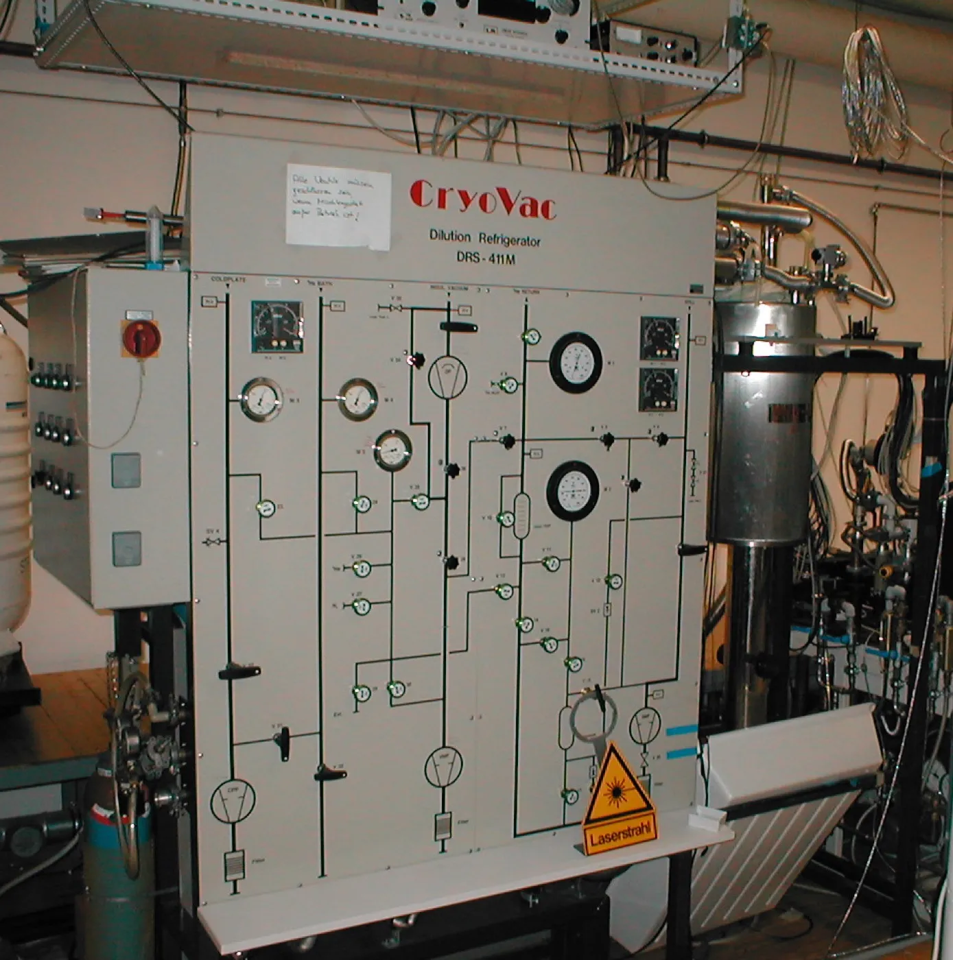 A helium dilution refrigerator photographed in a laboratory, with its stacked metal stages